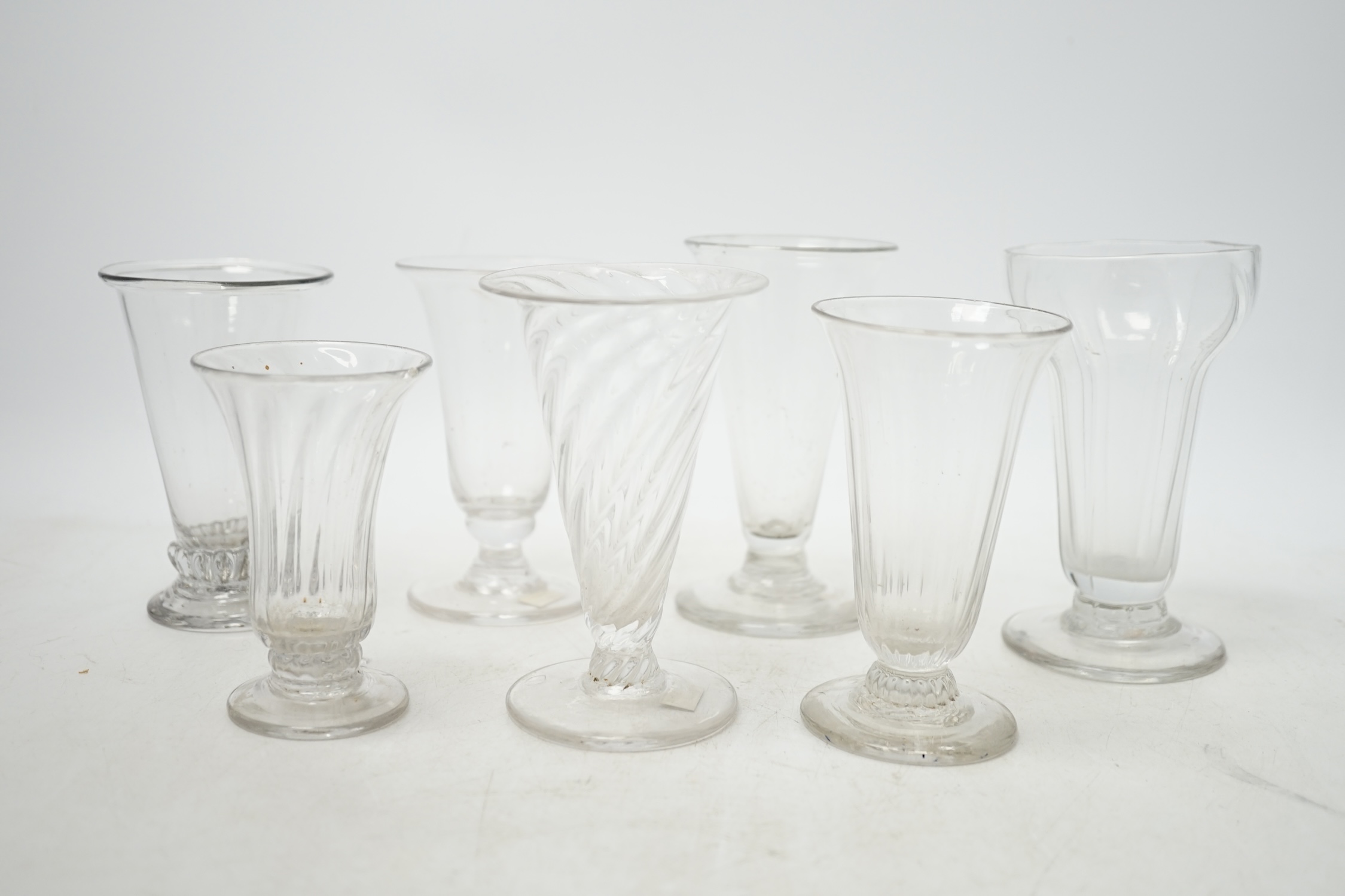 Seven 18th century jelly glasses, four with ribbed bowls, tallest 11.5cm. Condition - fair to good, chip to the rim of one and faults in the blowing.